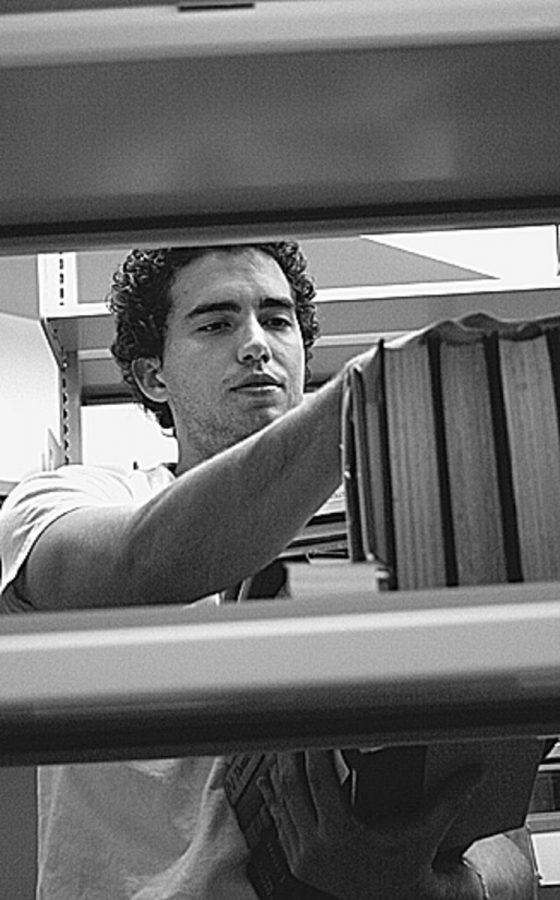 Brandon Porsandeh, 23, stacks books on new libraryÂ´s shelves.