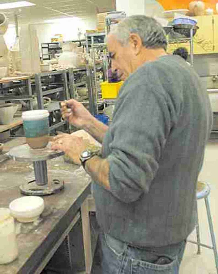 Art major, Karle Koereling, puts finishing touches on a piece he will sell at the MC ceramic sale. 