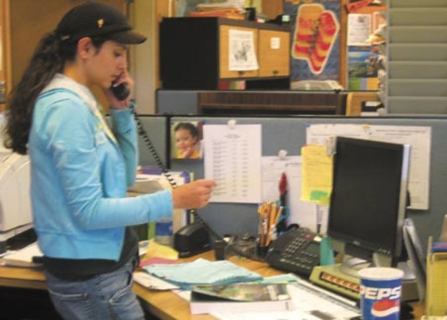 Maria Sanchez, 19, a Tutoring Center student assistant, helps a student on the phone.