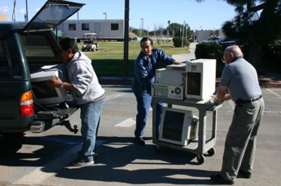 Left to right- Elio Lopez, Augie Castaneda, Albert L. Gesling load donated computers to be inspected, serviced and ready to be donated to students.