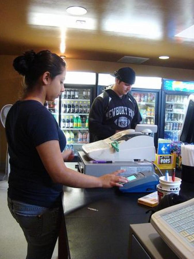 Eva Sanchez, 19, a criminal justice major, prepares to use the credit card machine.