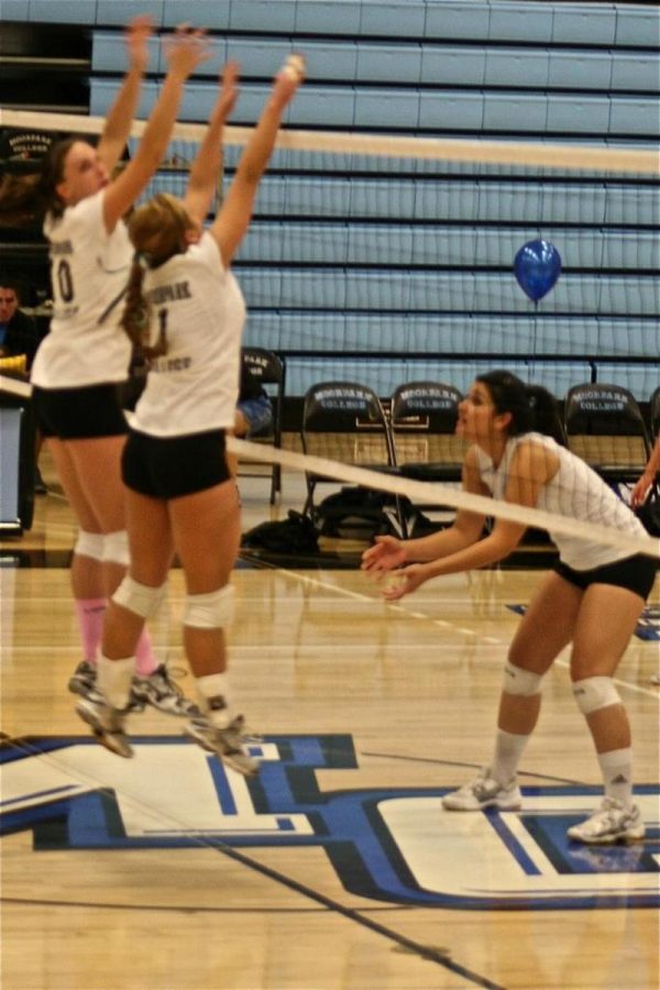 Raiders setter Olivia White and middleblocker Rachel Olinyk, both left, go up for a block during warm-ups before Tuesday night's WSC match.