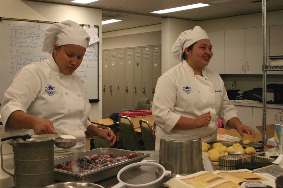Cece Block, 25, left, pours sugar on some mixed berries while Elizabeth Chaves, 20, rolls dough. The cullinary arts majors are making berry tortes to sell to Oxnard College faculty and staff.