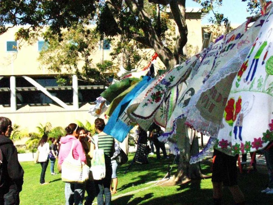 Students+at+Ventura+College+examine+a+clothesline.+Each+t-shirt+represents+a+victim+of+abuse.