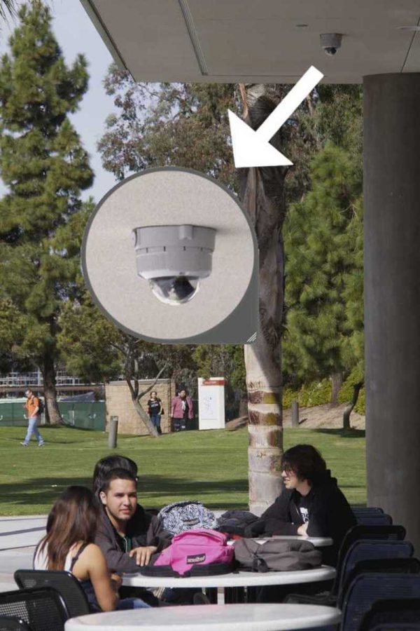 Oxnard College students sit at lunch tables outside the Student Union Center with new security cameras from the ceiling.