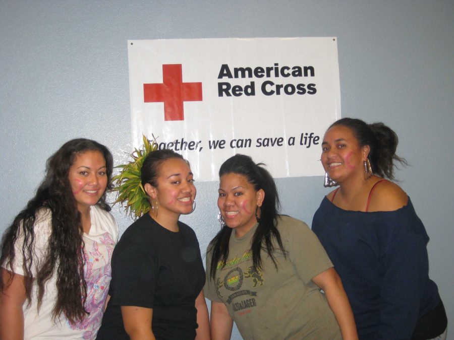 Samoan dance team members Aime Rose Auvae, Fialogo Liaina, Lago Seui, and Leilani Howard pose with an American Red Cross Banner. Proceeds from their cultural night were donated to help Haiti relief efforts.