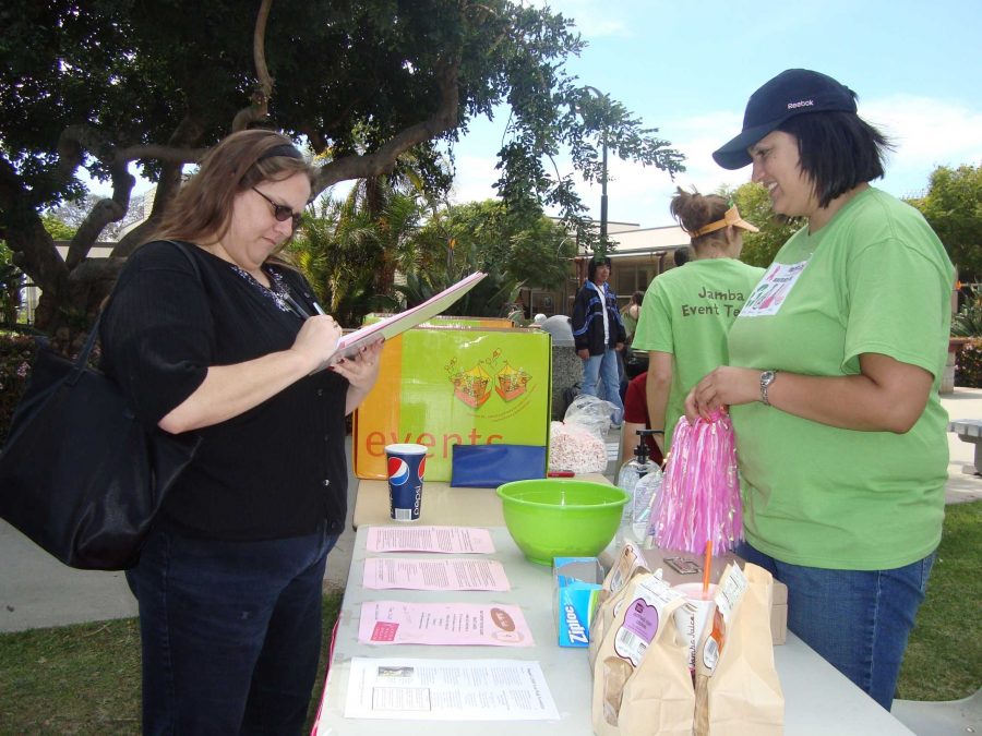 Leslie Spier, left, signs up for Raquel Riveras email newsletter. Rivera informs her followers on upcoming fundraising events and how to contribute to the Avon Walk for Breast Cancer.
