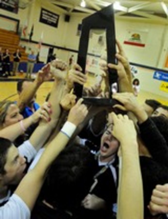 The Moorpark College volleyball team holds up the state championship trophy after sweeping Orange Coast College April 24. 