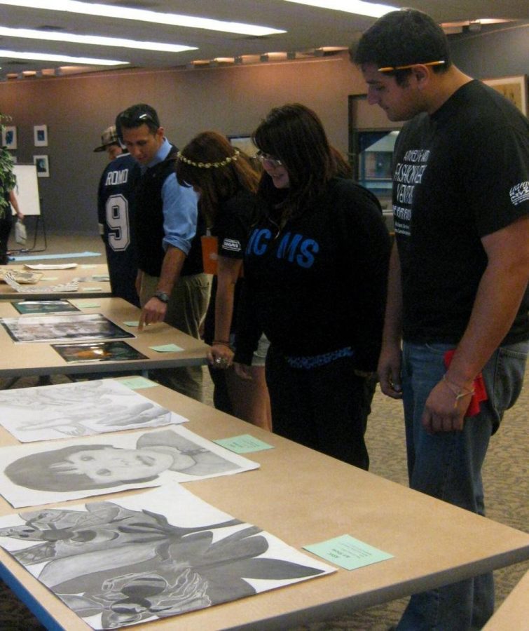 Students check out a diverse collection of artwork at ASVCs student art exhibit in the tutoring center.