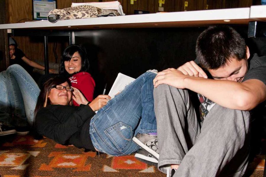 Wendy Gutierez, Bianca Ordaz and Daniel Ontiveros  duck and cover during The Great California Shakeout at Oxnard College on Oct. 21.