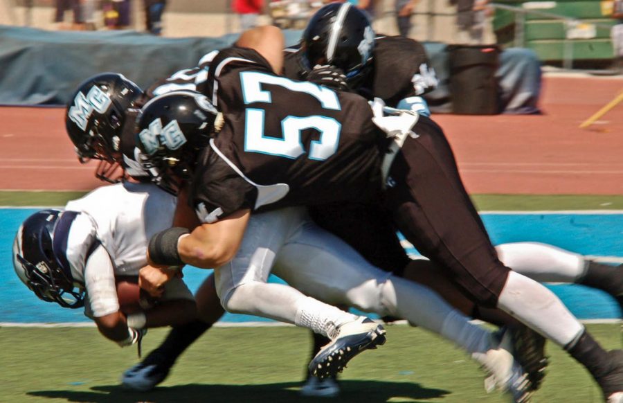 Moorpark Raider Chris Pinneri, 57, and two other teammates tackle Citrus college's, Jo Jo Curiel. The game ended with Moorpark losing 29-16 on Sept. 8th 2012 -Photo By Brittany Tackett