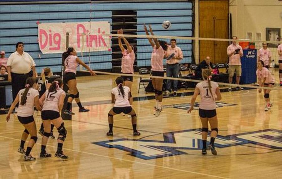 Kalene DeGuzman, 9, from Moorpark College Womens Volleyball Raiders spikes the ball through two players attempt to stop her.