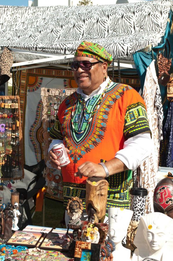 Lowell Pumphrey Jr., a Vietnam veteran and designer of African attire, preps his booth. He, along side many other vendors, are setting up their displays and decorating them with vibrant colors and elegant designers that embody the many different cultural influences of the world. 