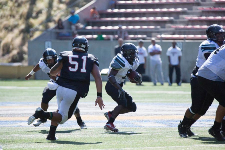Raider runningback Josh Robles gets the handoff from quarterback Nick Davis on a right side sweep.
