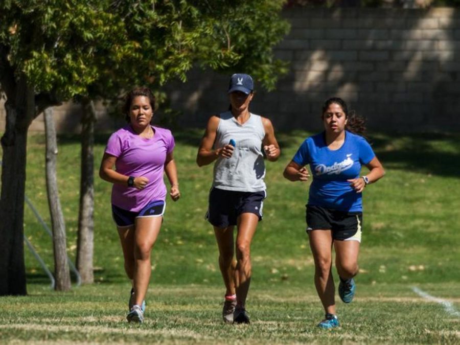 A trio of runners, Ana Villagran (left), Coach Traci Kephart (center), and Nayely Perez (right) begin endurance at Campus Canyon Park in Moorpark, California, Oct. 14.