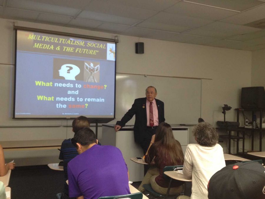 Interim President Dr. Bernard Luskin presents in front of a full classroom on Multicultural Day.