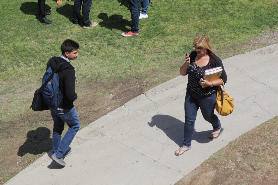 Students walk across campus glued to their phones.