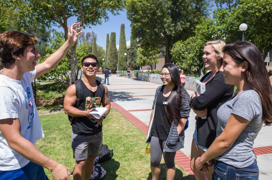 Tristan Lyga (left), 18, shares a funny story with friends along Raider Walk on Sept. 4. 
