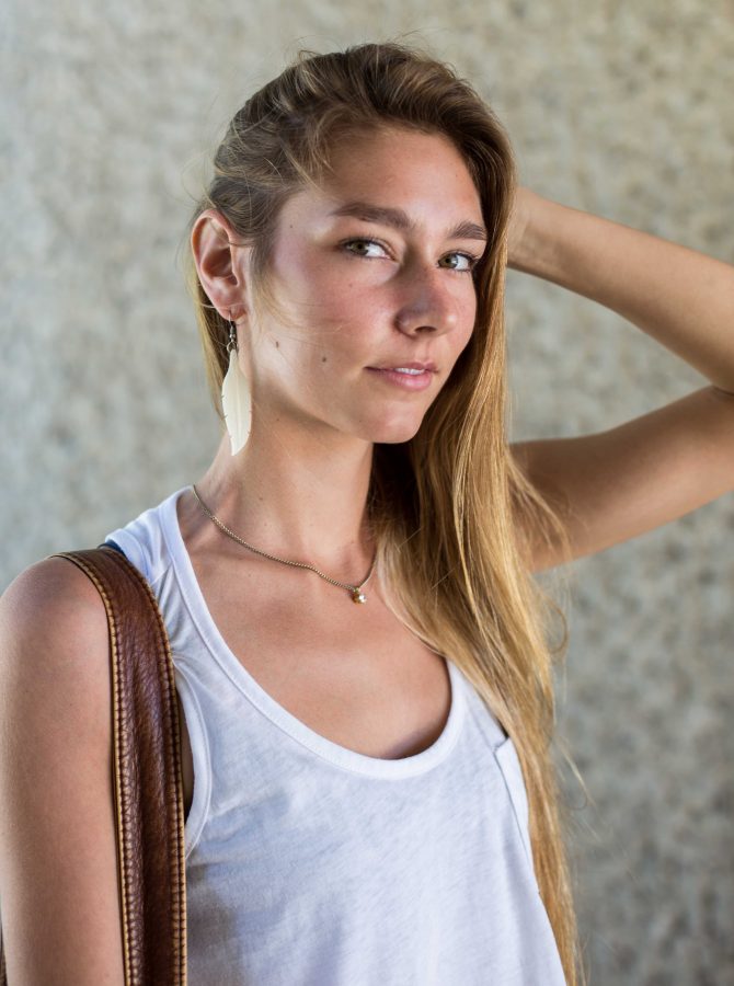 Alexa Darough, 18, shows off her feather earrings on campus on September 18. Photo credit: Travis Wesley