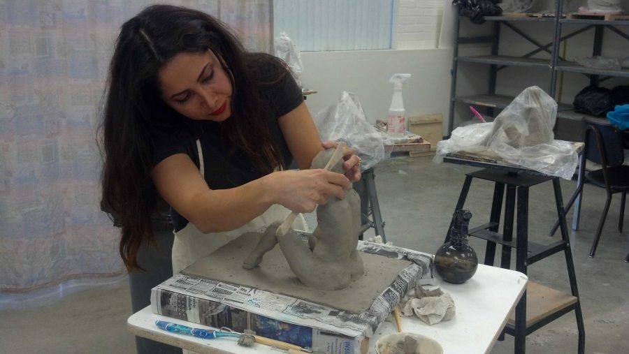 Iranian born Moorpark College student Mojgan Shajarian diligently works on her sculpture of a live model for her sculpting class.