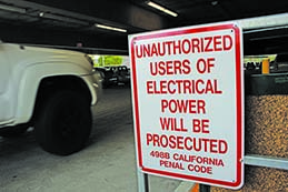 A sign at the entrance of the parking structure warning students of the consequences of unauthorized  use of the campus’ electricity. Photo credit: Brian Varela