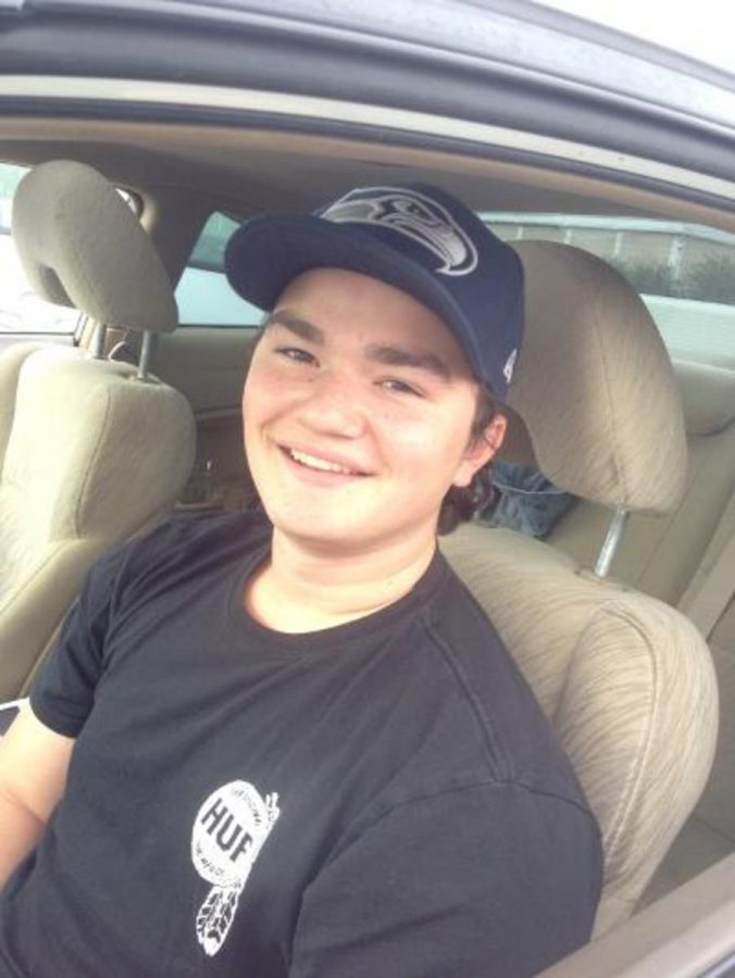 Liam Wilson sitting his car wearing his Seattle Seahawks hat excited for the game. Photo credit: Alan Ruiz