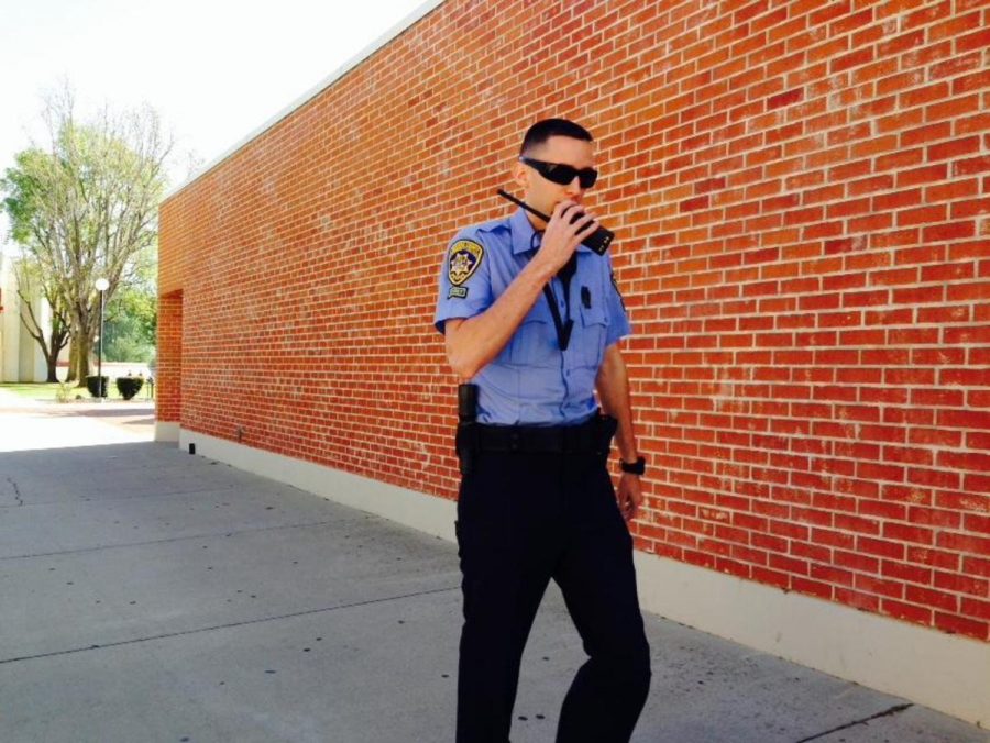 Police Cadet Spencer Neveaux speaks over his walkie talkie on his way to the parking lot. Photo credit: Jon Suarez