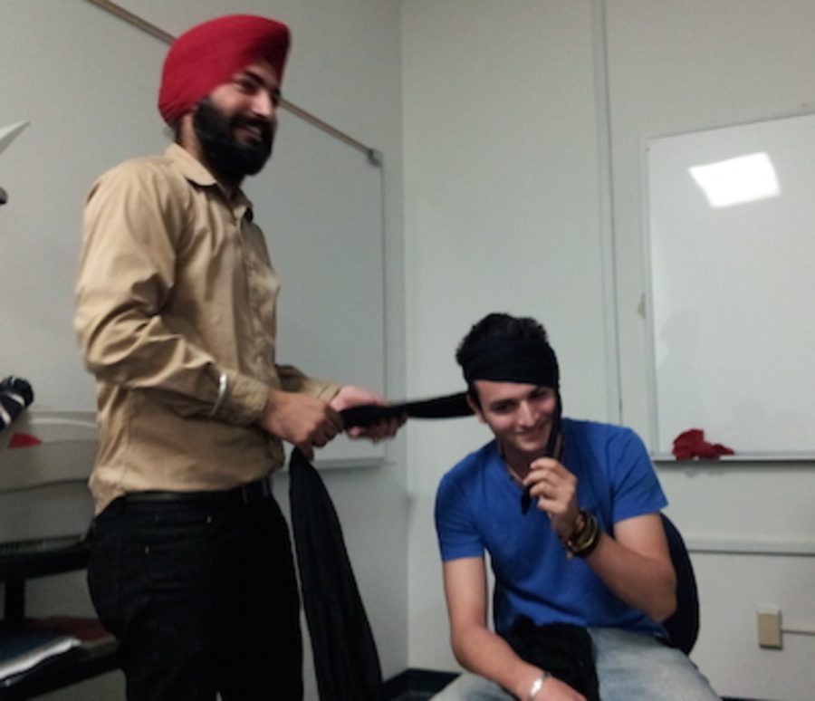 Manmeet+Singh%2C+left%2C+helps+Junaid+Shah+tie+a+traditional+Sikh+turban+during+the+presentation.+Photo+credit%3A+Frank+Ralph