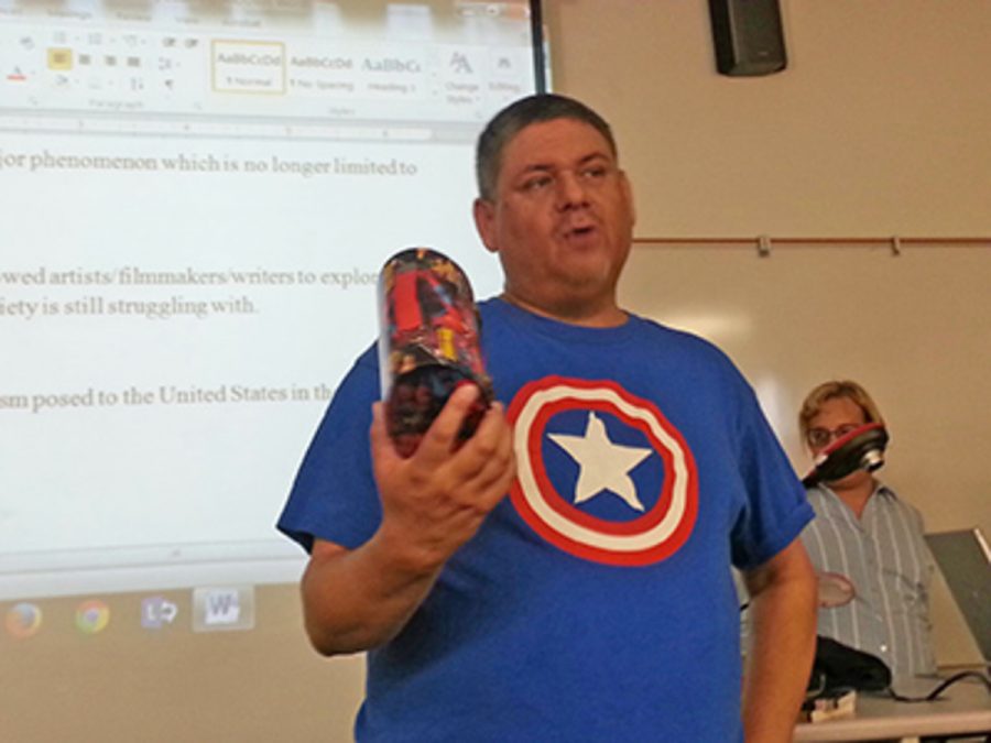 Steven Pfeffer showing off Captain America Issue #1 to the class. Pfeffer was up there presenting the history of superheroes, and what impact they have had on the political culture today. Photo credit: Chase Oliver