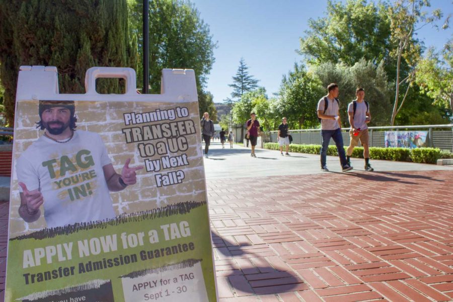 Students walk pass the Transfer Admission Guarantee sign along raider walk. T.A.G. applications are due by the end of September. Photo credit: Nikolas Samuels
