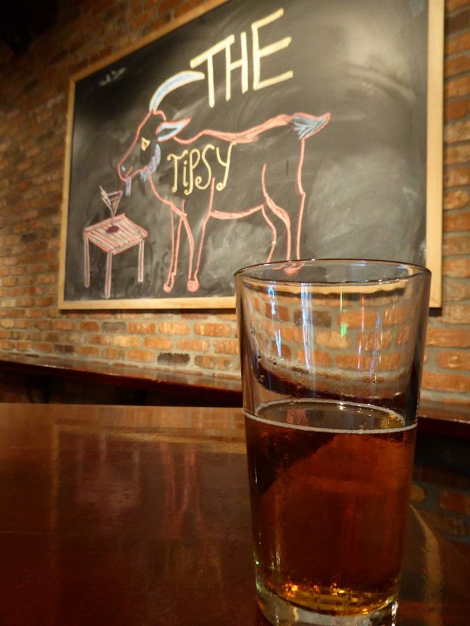 A glass of cold beer from the local 805 Brewery sits in front of a hand drawn sign for the local bar The Tipsy Goat. Photo credit: Tom Fields