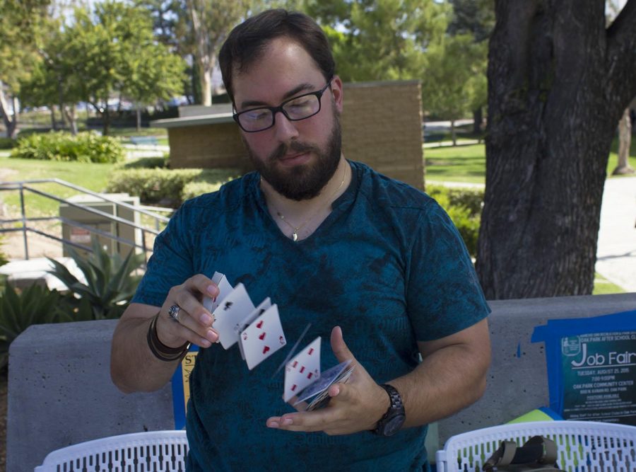 Daniel Rathaus, the President of the Magicians Society, shows card tricks to potential members to bring attention to his club. Photo credit: Nikolas Samuels