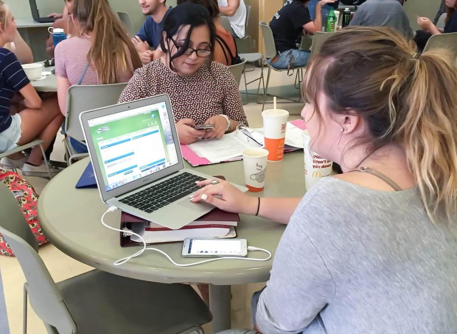 Moorpark College students, Meena Zulmai, 18, and Caitlyn Stanescu, 18, use their Apple devices to access student services on campus. Photo credit: Shahni Ben-Haim