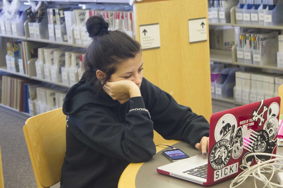Natalie Lebova rests her head on her hand while she studies in the library. Photo credit: Nikolas Samuels