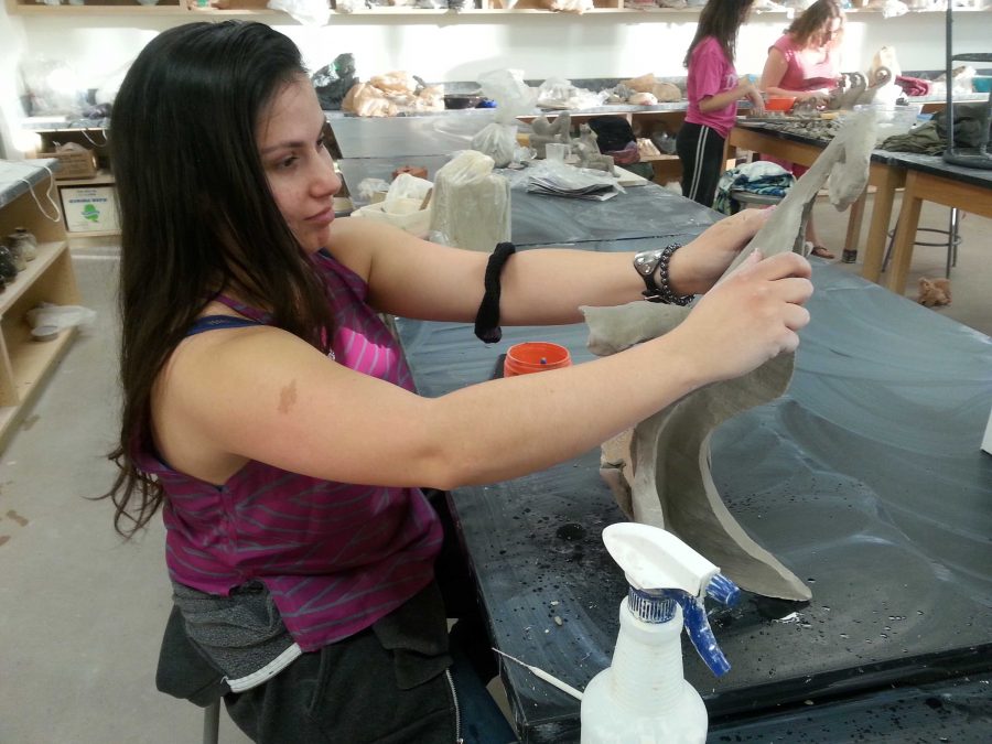 Faith Stone, 20-year-old anthropology major,  works on her ceramics piece for the sale this Dec. Photo credit: Janett Perez