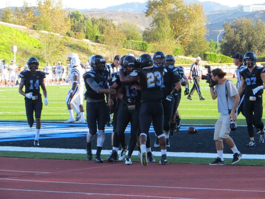 The Raider offense celebrating with quarterback Kado Brown as he runs in for a touchdown to give his team the lead late in the fourth quarter. Photo credit: Nick Gurrola