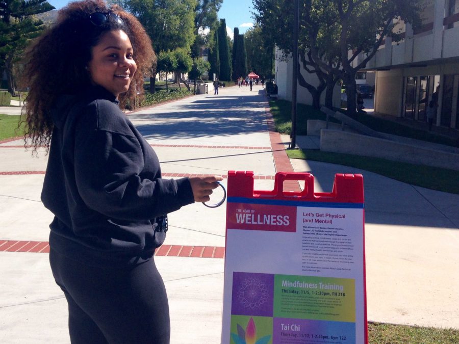Mecca Holtz, a 21-year-old CLU student, putting up Year of Wellness posters around campus. Photo credit: Bridget Fornaro