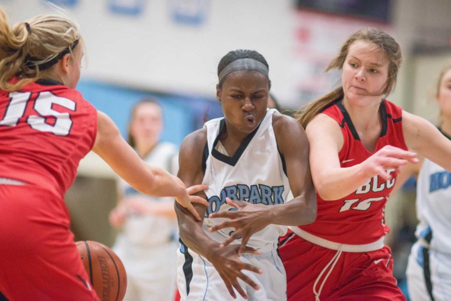 Cydney Bolton tries to drive the ball to the hoop between two defenders. Photo by James Schaap