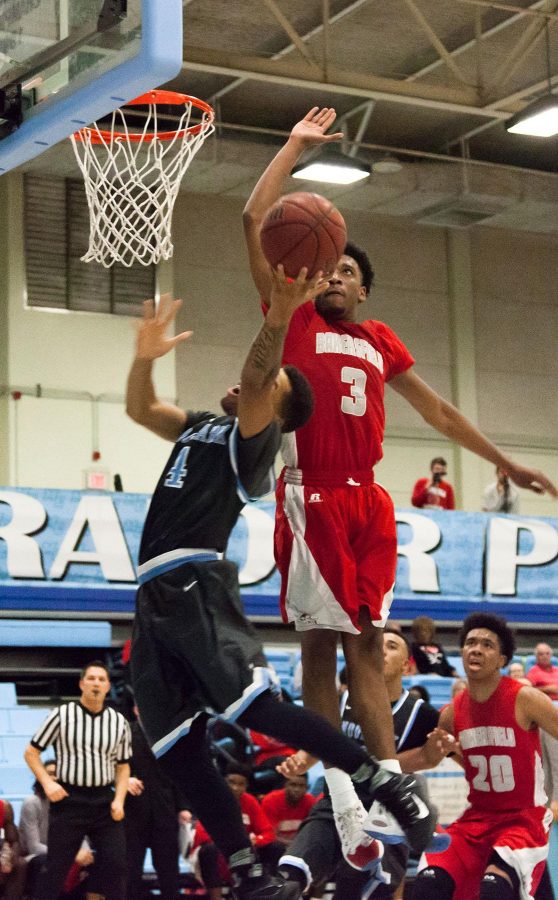 Raider Chris Fields leaps for the basket before being stuffed by Bakersfield College’s Lawrence Moore in Friday night’s playoff game at the Raider Pavilion.