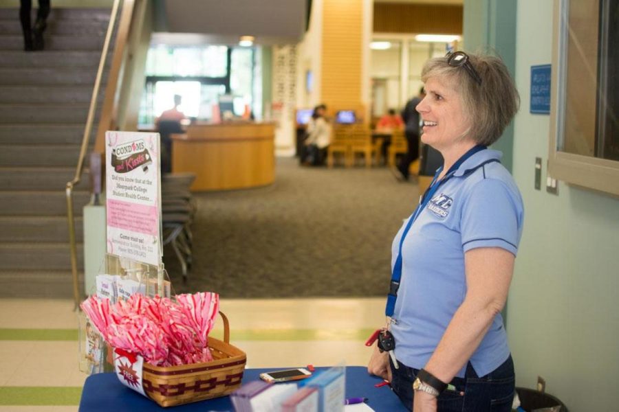 Allison Barton, health educator, encourages students to stay safe on Valentines Day by handing out condoms and Hersheys Kisses in Fountain Hall. Photo credit: Gabrielle Biasi