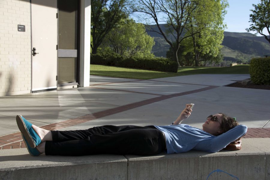 Kasey Dicks, a 25-year-old business major, soaks up the sun during her break between classes. Photo by Melissa Westervelt