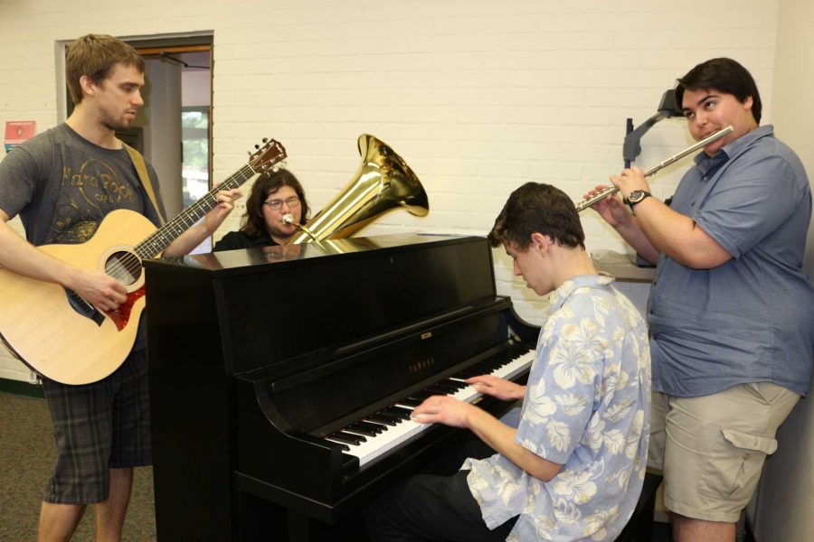 Left to right: Max Epstein, 24, music major, Joseph Alex Reyes, 20, music major, Connor Lott, 19, business major, and Kyle Holcombe, 19, music major, practice as one of the many groups to perform in the April show. Photo credit: Christine Rasmussen