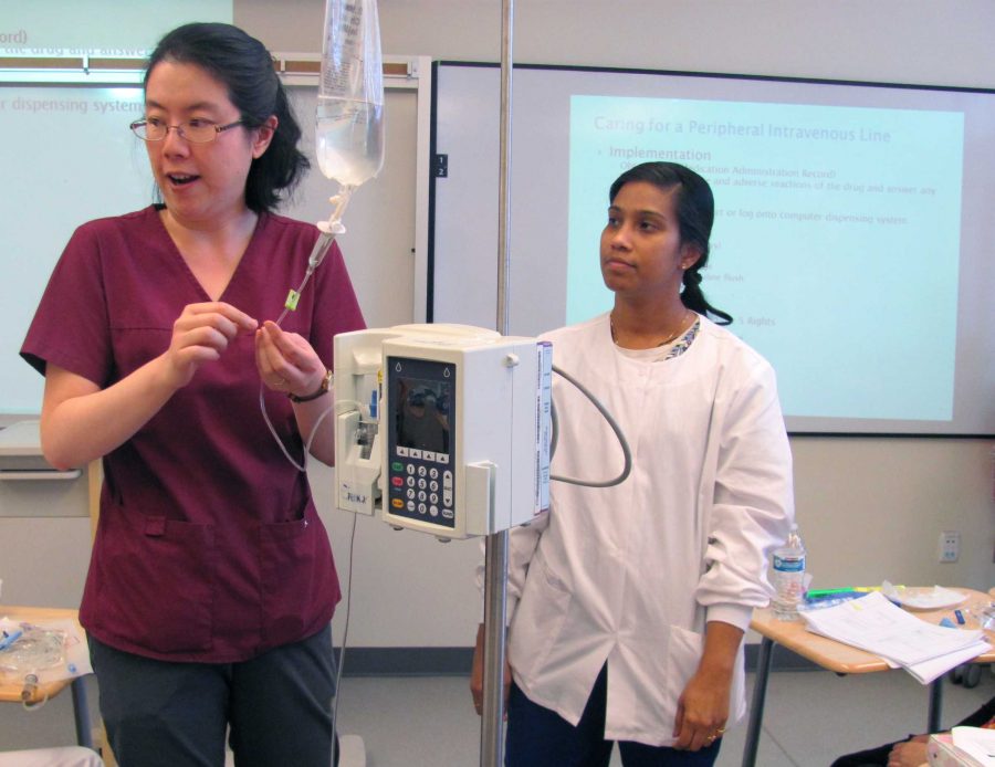 Christina Lee, left, nursing instructor, demonstrates to the students how to work with IV as Jeny Joy, nursing instructor, watches Lees demonstration on Wednesday, March 16. Lee will be the instructor for the new nursing courses. Photo credit: Son Ly