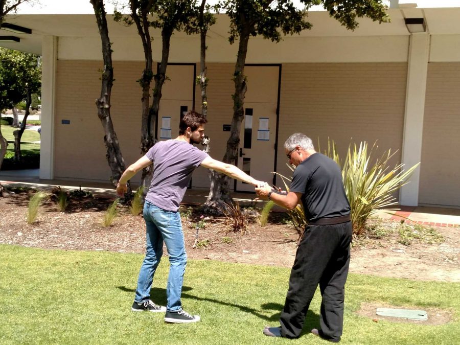 Instructor Chad Basile, right, shows a student how to get away from a fight without hurting anyone. Basile and Leeann Mulville ran a marital arts seminar from 10 a.m. to 2 p.m. at Multicultural Day on how students can defend themselves from an attacker. Photo credit: Nick Gurrola