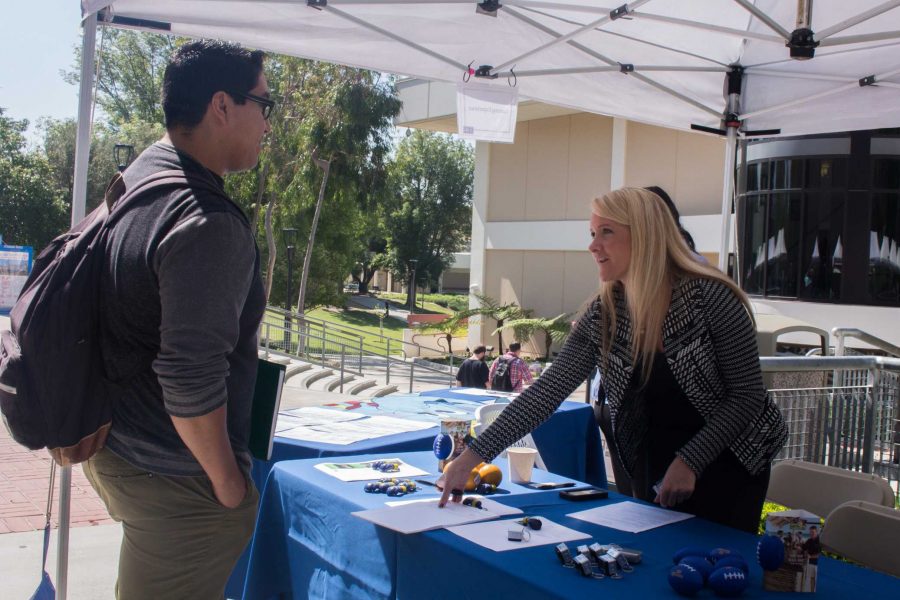 Michael Hernandez, left, 24, biology major, looking around the Job and Career Expo at Moorpark College for new job opportunities that would interest him on April 13. 