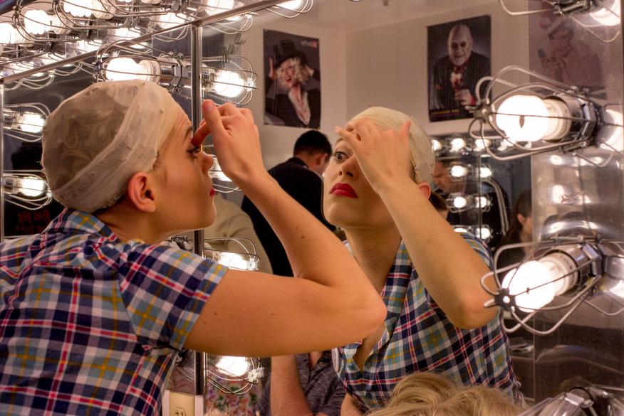 Annie Sherman, Velma, applies her make-up before putting on her costume for the first night of dress rehearsals for “Hairspray” on Feb. 29.