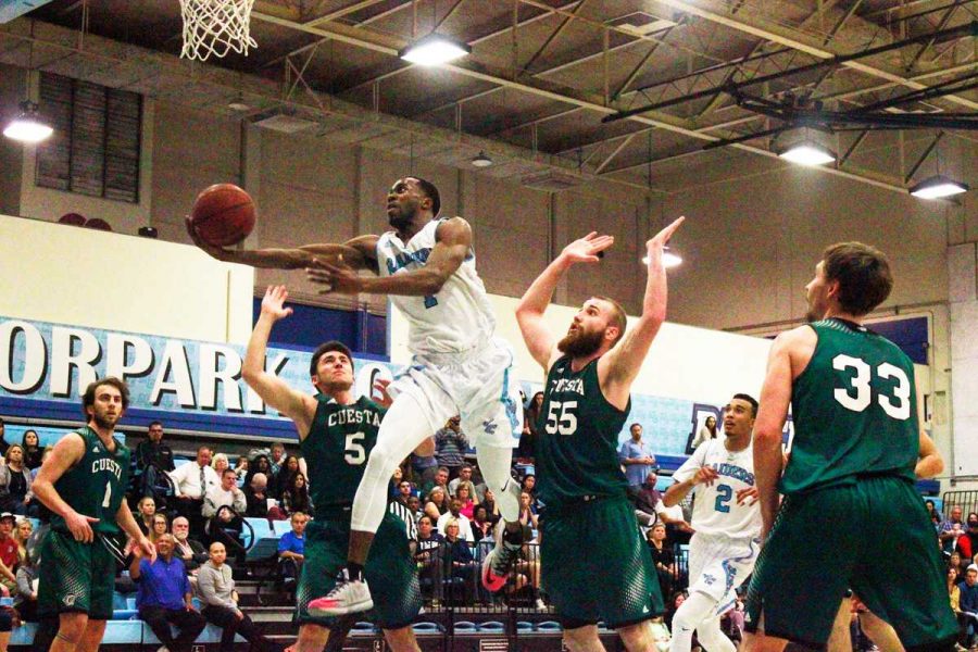 Guard Joshua Brooks drives the ball to the basket for a layup against two Cuesta opponents at the season closer on Feb. 20. The Raiders won 107-100 in double overtime. 