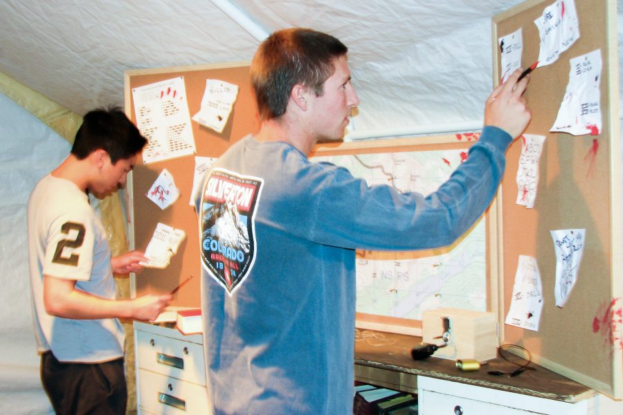 Austin Plambeck (right), 19, Environmental Science major, works quickly alongside Jeffrey Kotake (left), 18, Business major, to solve the complex riddles and puzzles posted on a chalkboard that need to be complete in order to escape The Outpost, on the night of Oct. 8 in the Simi Valley Town Center. Photo credit: Andrew Mason