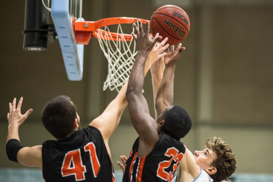 Garrett Bilby, Center, tries to make a basket as two Ventura College defenders attempt to block the ball. Photo credit: James Schaap