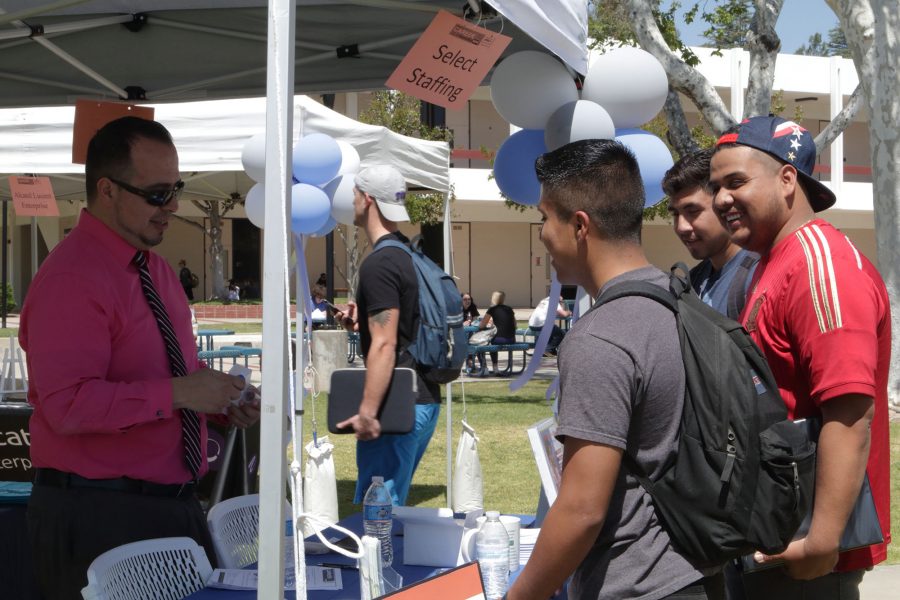Career Day at Moorpark College, located on the campus quad, Moorpark, Califor., on Wednesday afternoon, Apr. 5, 2017. Select Staff Personal Supervisor, David Andrade speak to Francisco Lopez, 21 (front), Cristian Zaragoza, 22 (middle), and Jose Ruiz, 20 (back) on how to apply to the agency. (The Student Voice / © Jesse M. Watrous)